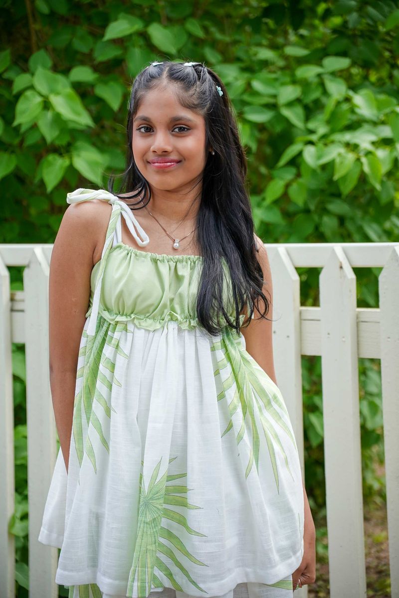 White summer dress with a green leaf print and tie straps