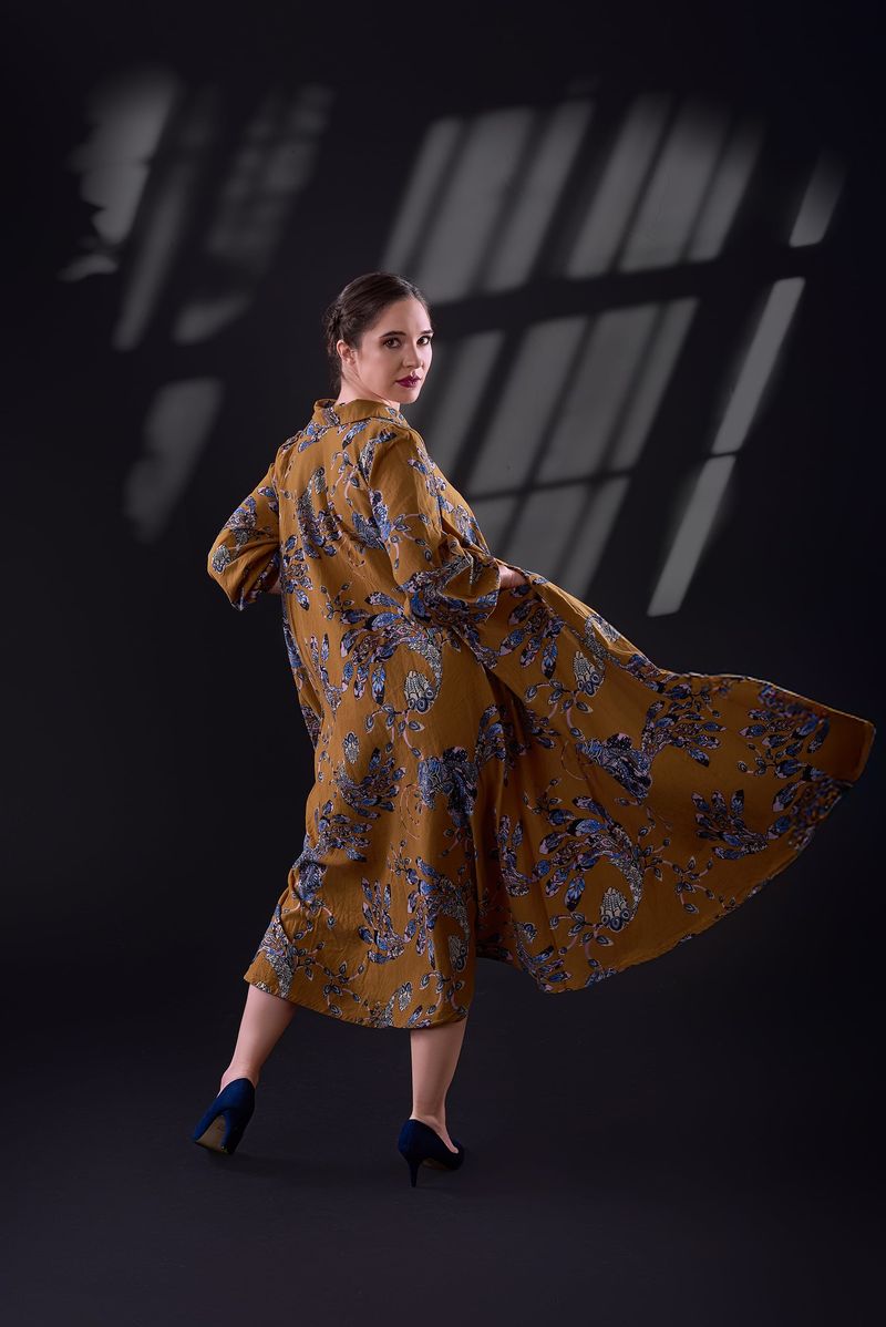 The mustard floral dress in motion, showing its wide flowing skirt