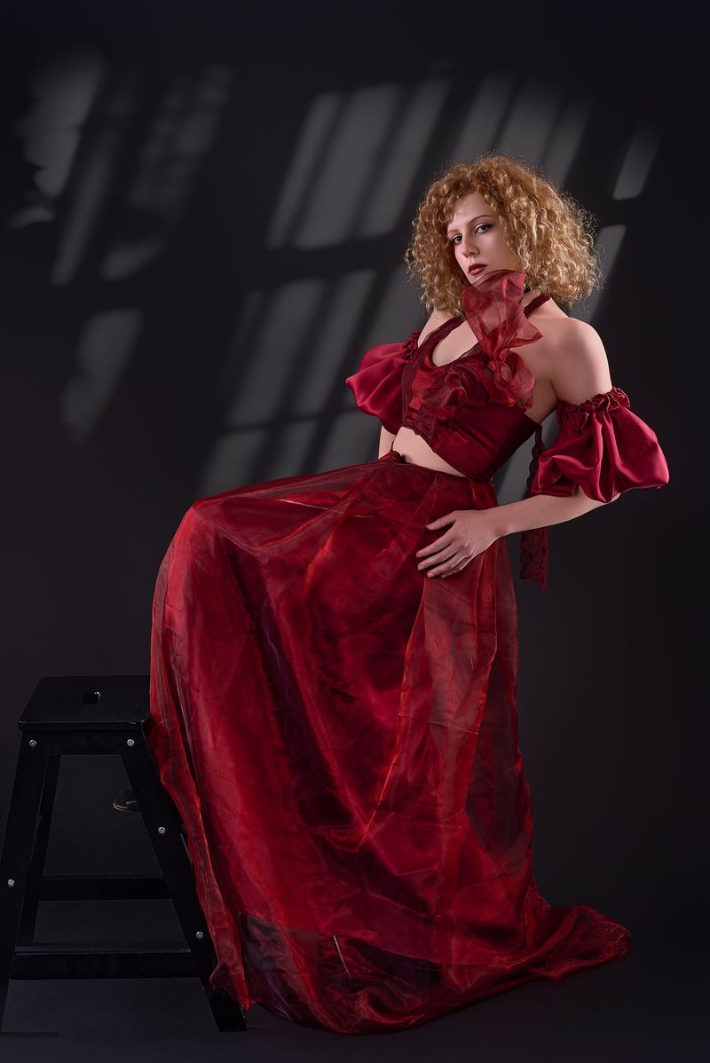 Red organza evening gown with puff sleeves and a cut-out bodice, designed by Thenu in Tampere