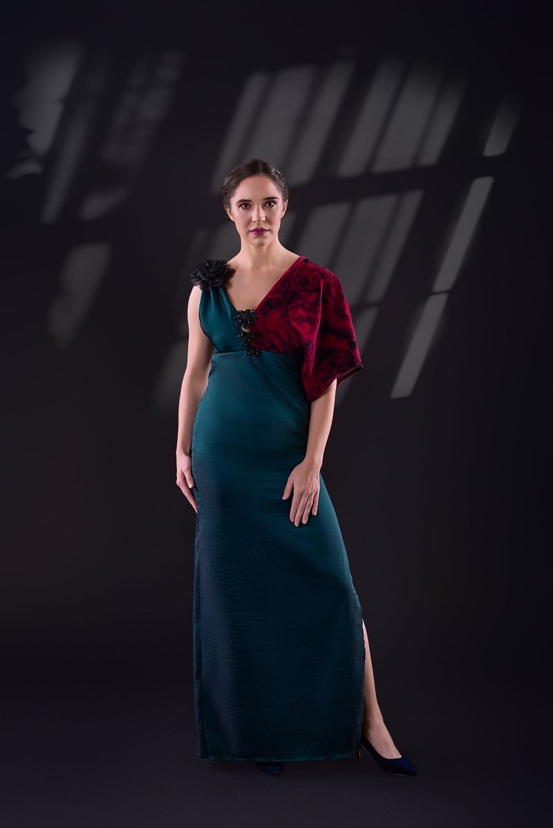 Fitted teal gown with an asymmetric red draped shoulder